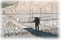 man crossing footbridge in Shimshal, Pakistan